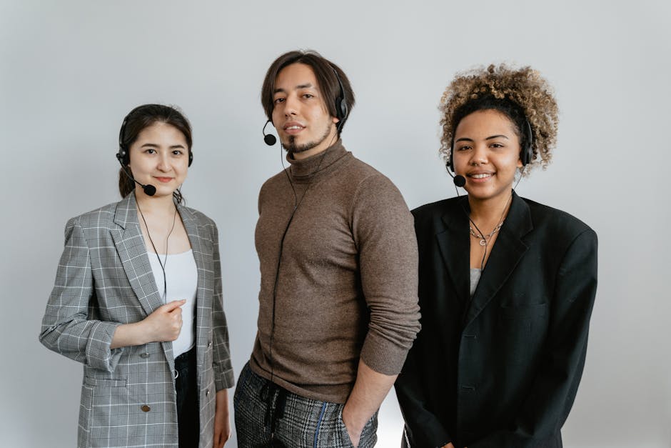 Three diverse customer support representatives wearing headsets and standing together