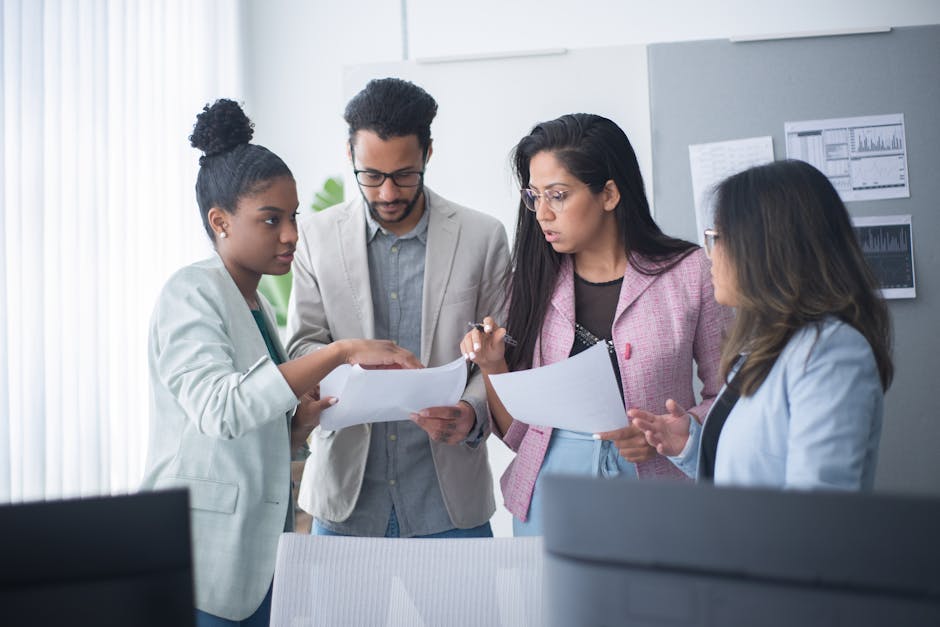 A diverse group of professionals engaged in a focused team meeting within an office environment